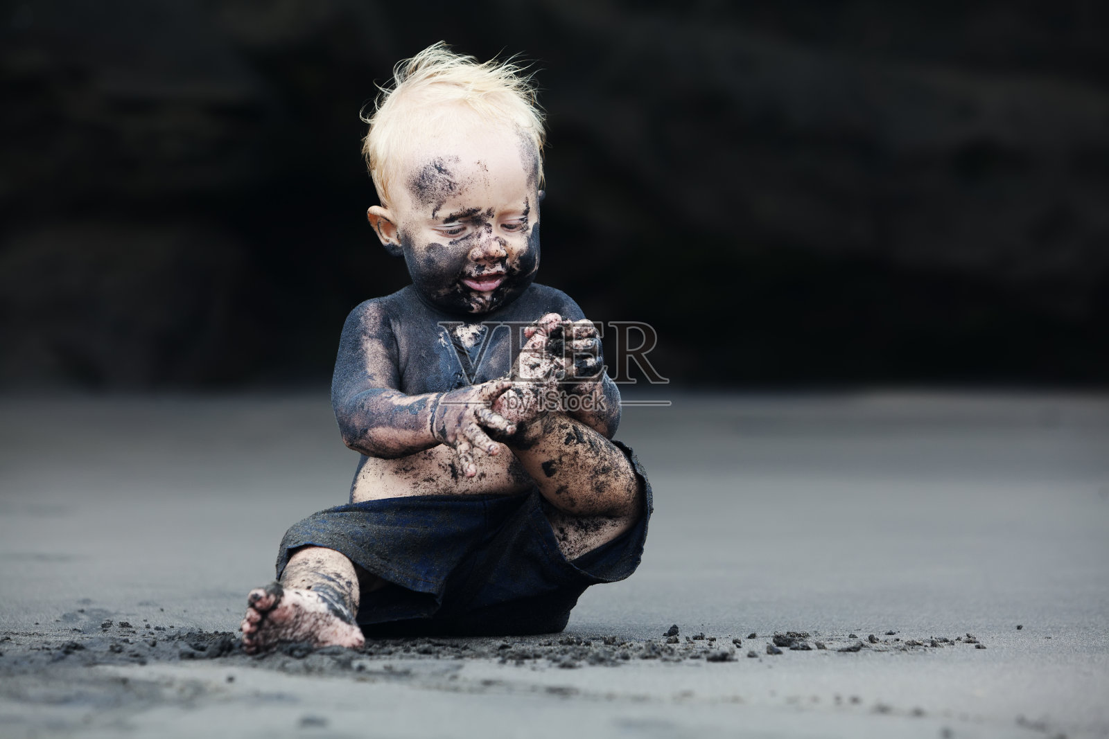 黑沙滩上脏兮兮的孩子的肖像照片摄影图片