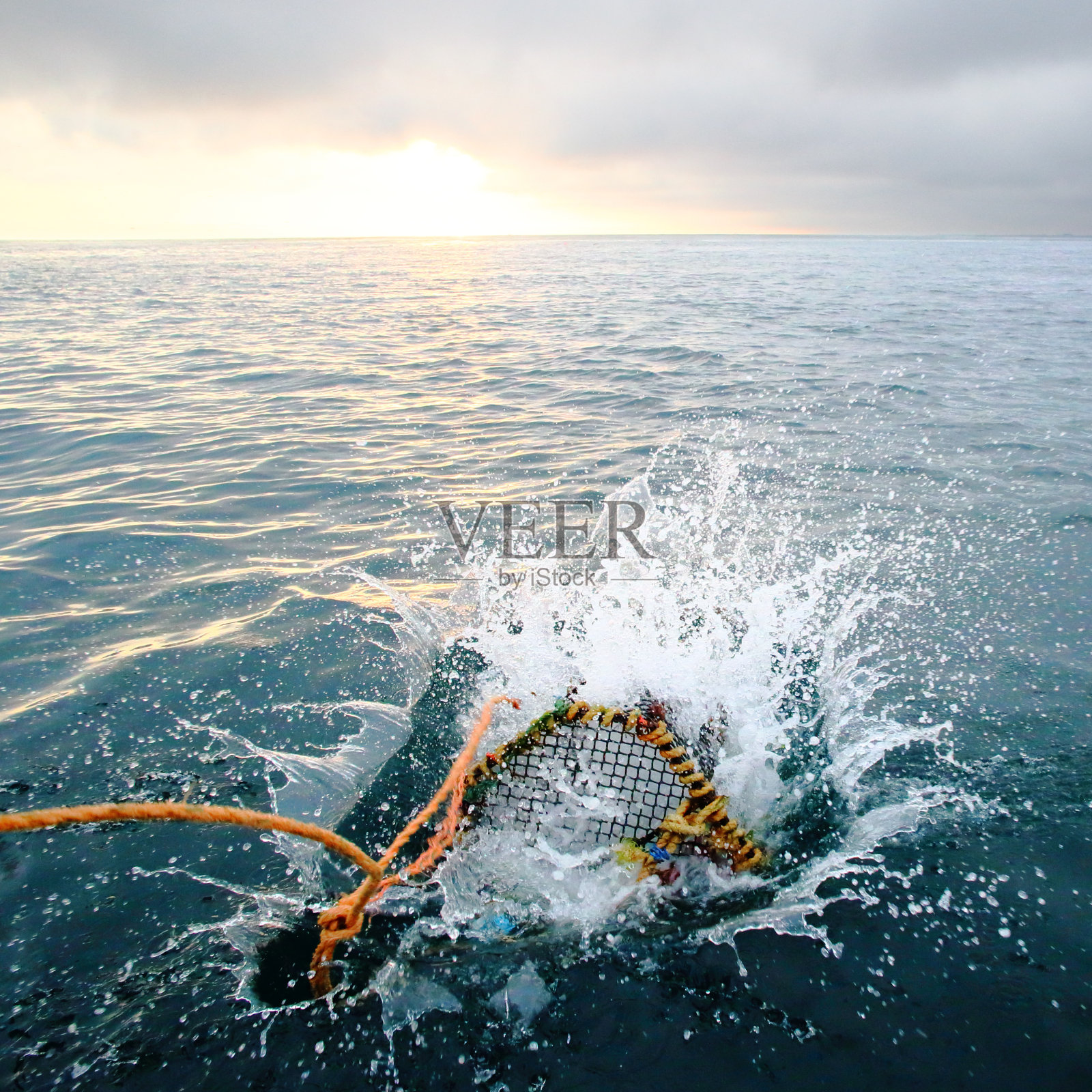 黎明时在海里溅起鱼篓照片摄影图片