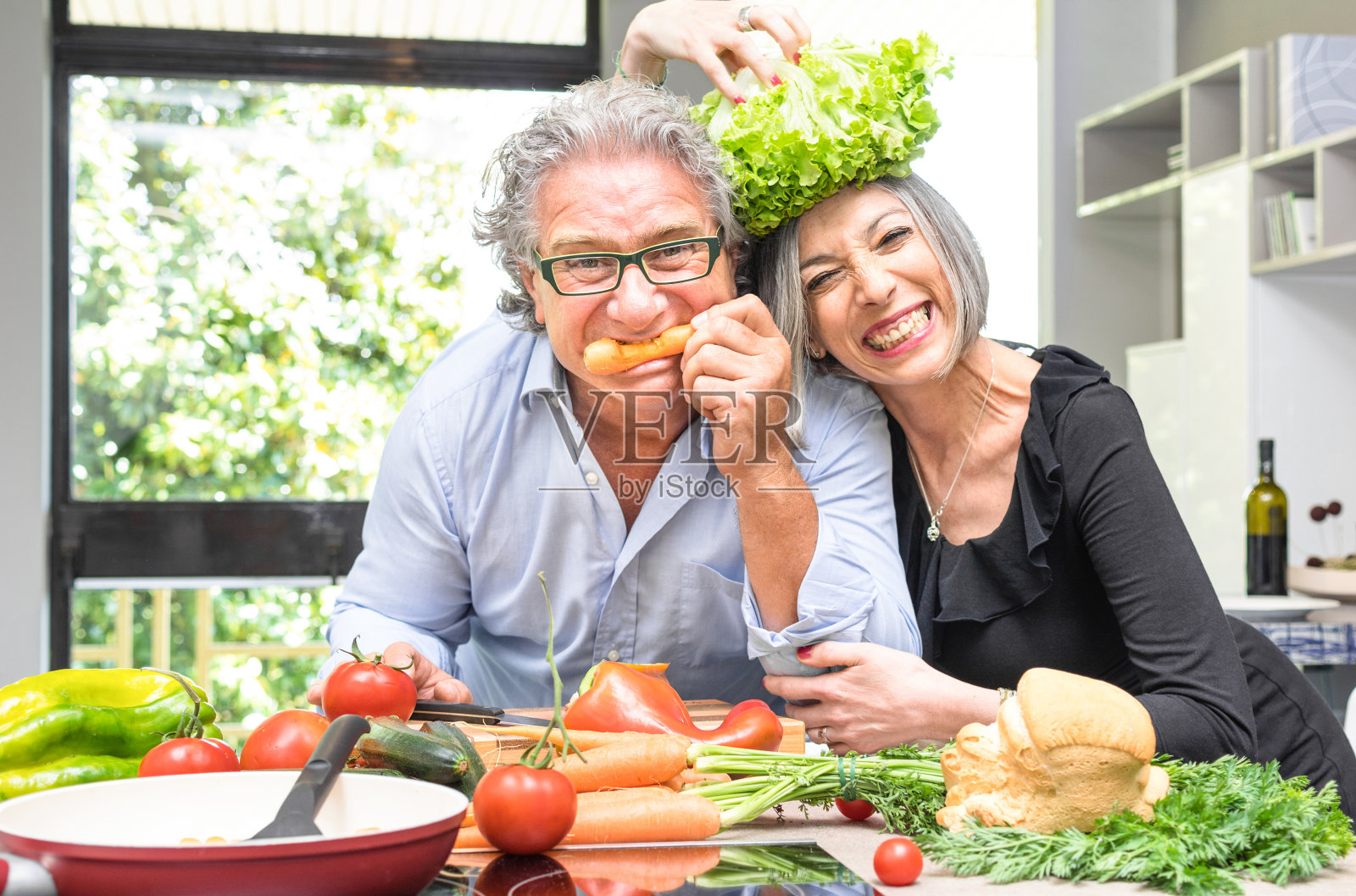 老夫妇在厨房里一起烹饪健康的食物照片摄影图片