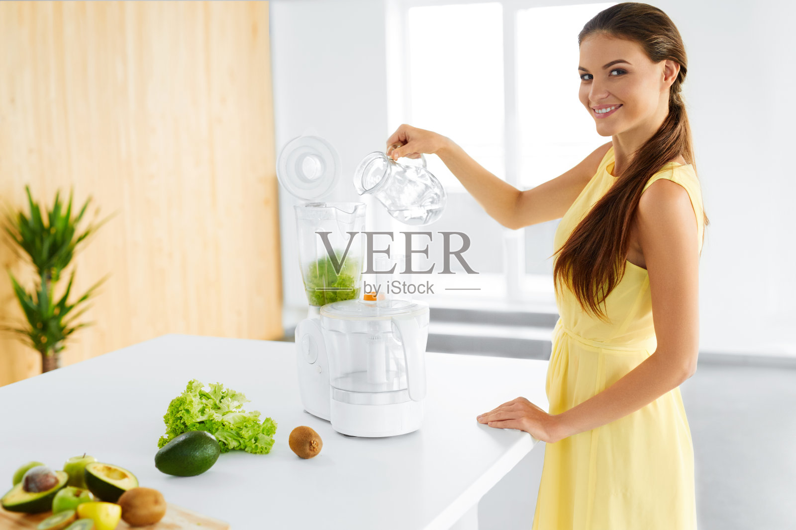 健康饮食。素食女性准备绿色排毒汁。饮食照片摄影图片