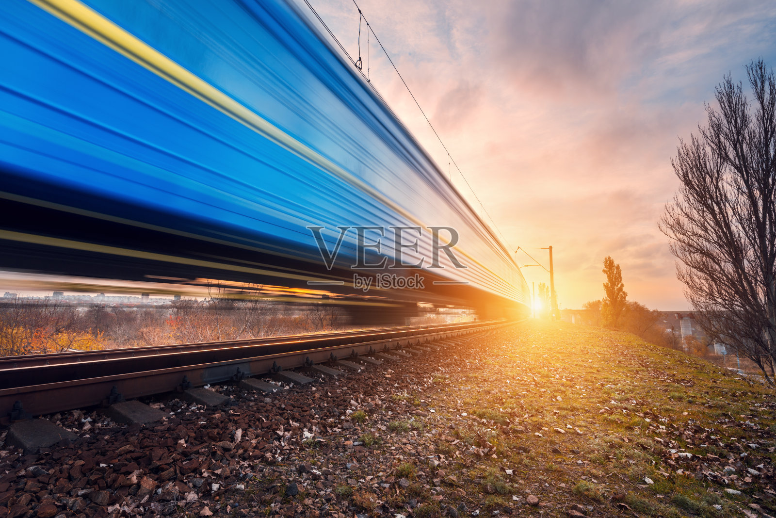 高速蓝色旅客列车在铁路轨道上运行照片摄影图片