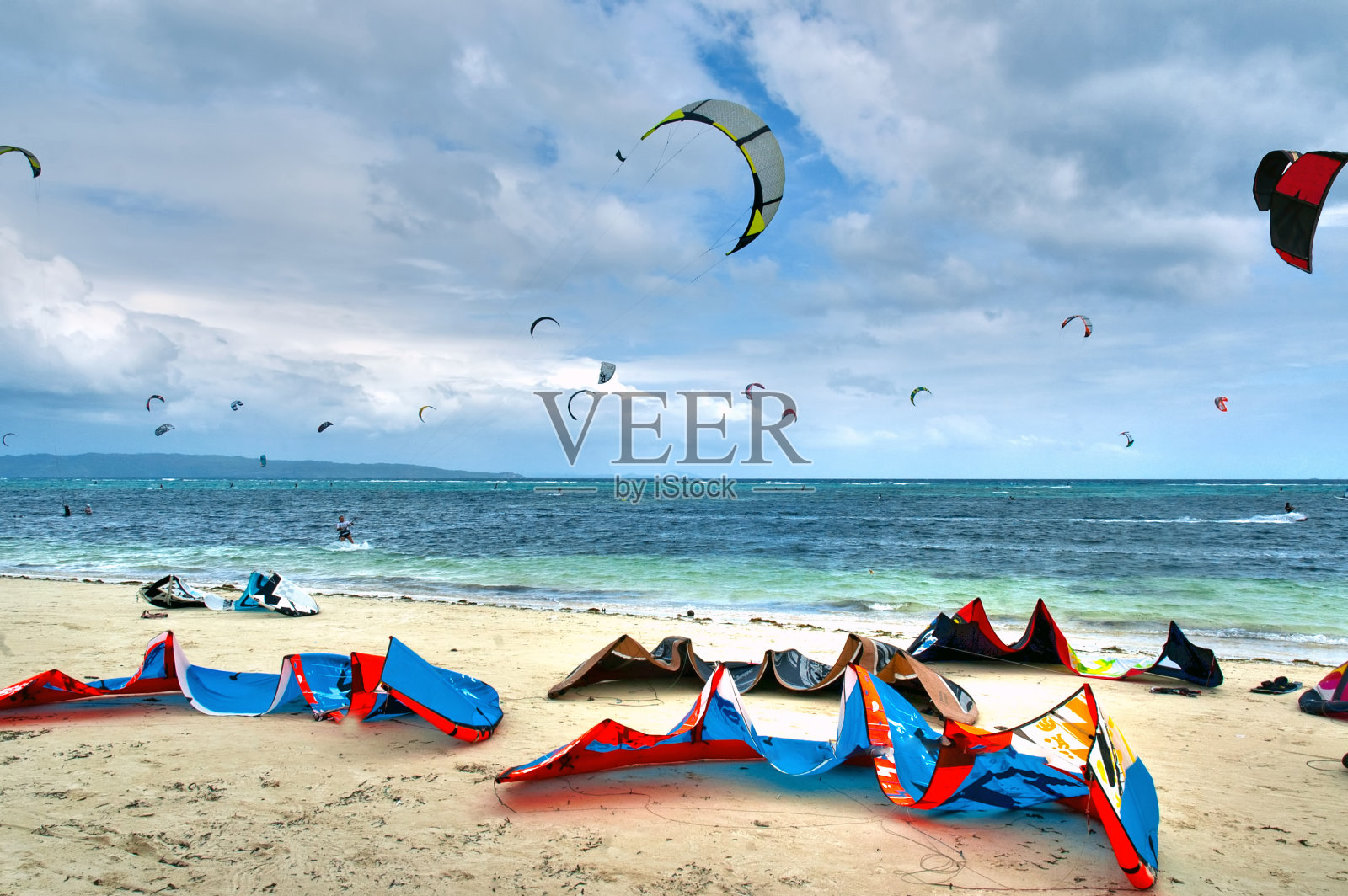 白色沙滩上五颜六色的风筝冲浪设备照片摄影图片