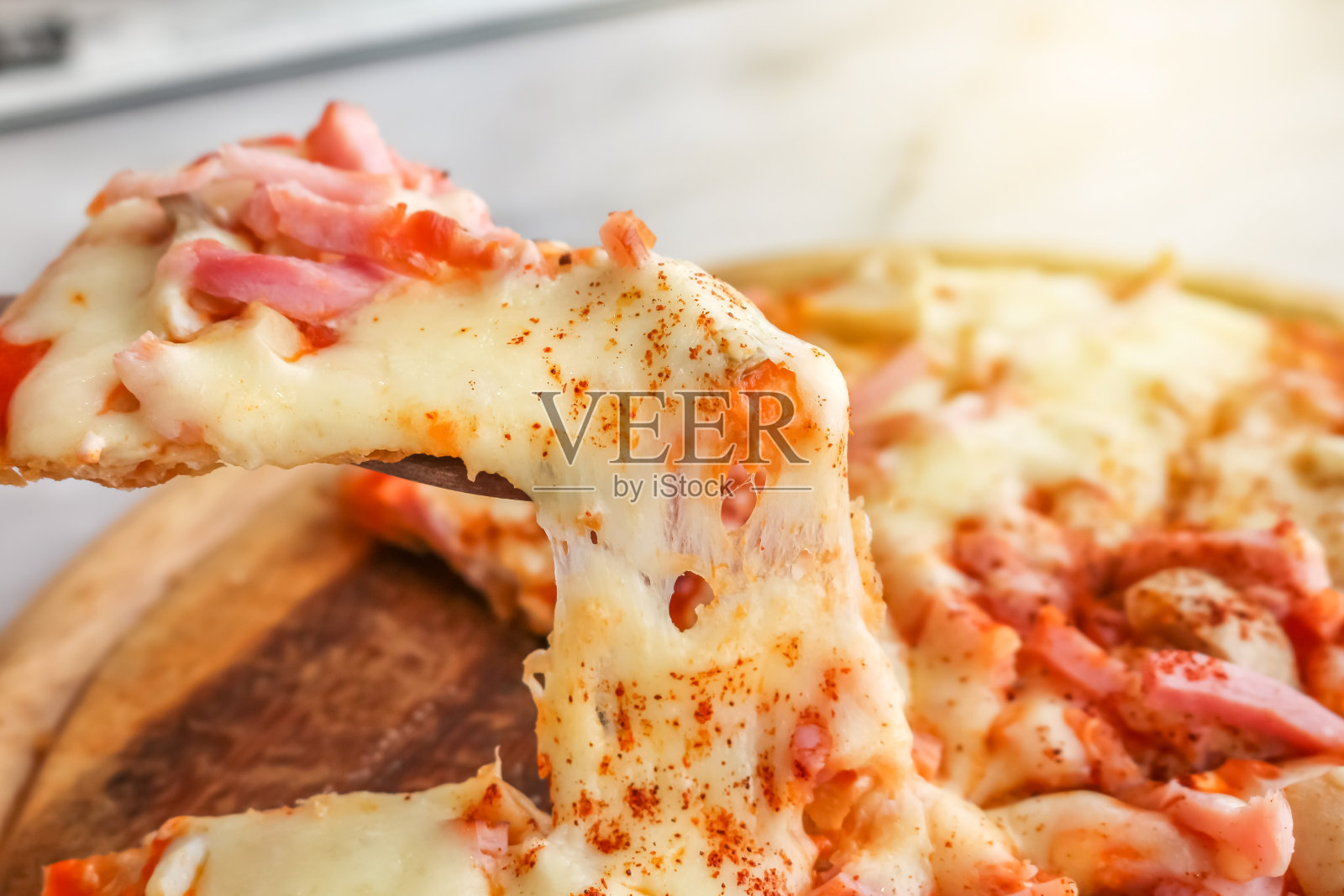 热披萨片和融化的奶酪在白色花岗岩上照片摄影图片