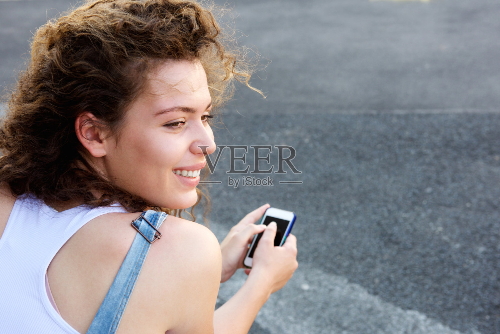迷人的微笑女人在户外使用智能手机。照片摄影图片_ID:328529986-Veer图库