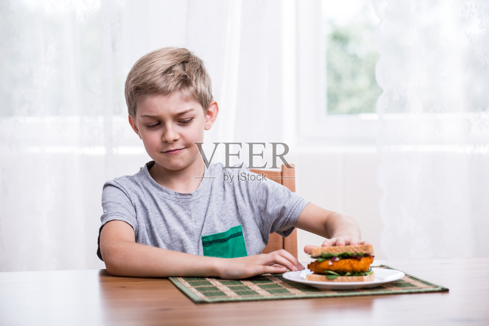 挑剔的孩子吃鸡肉三明治照片摄影图片