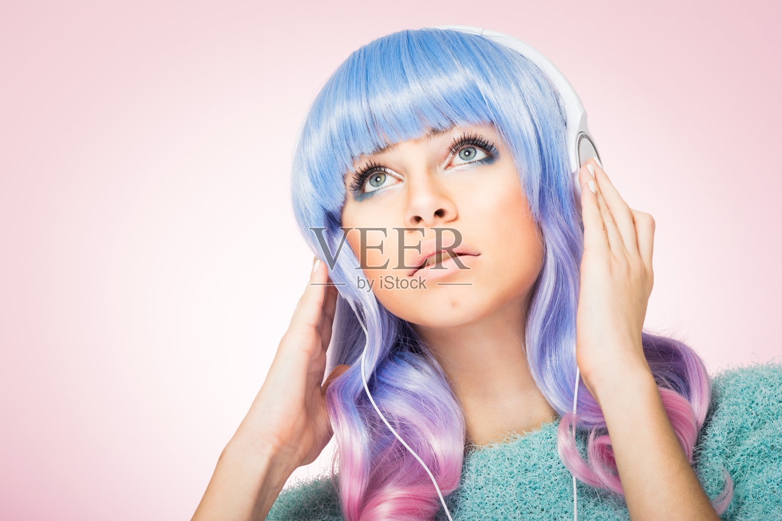 漂亮的年轻女子，蓝粉头发，戴着耳机照片摄影图片
