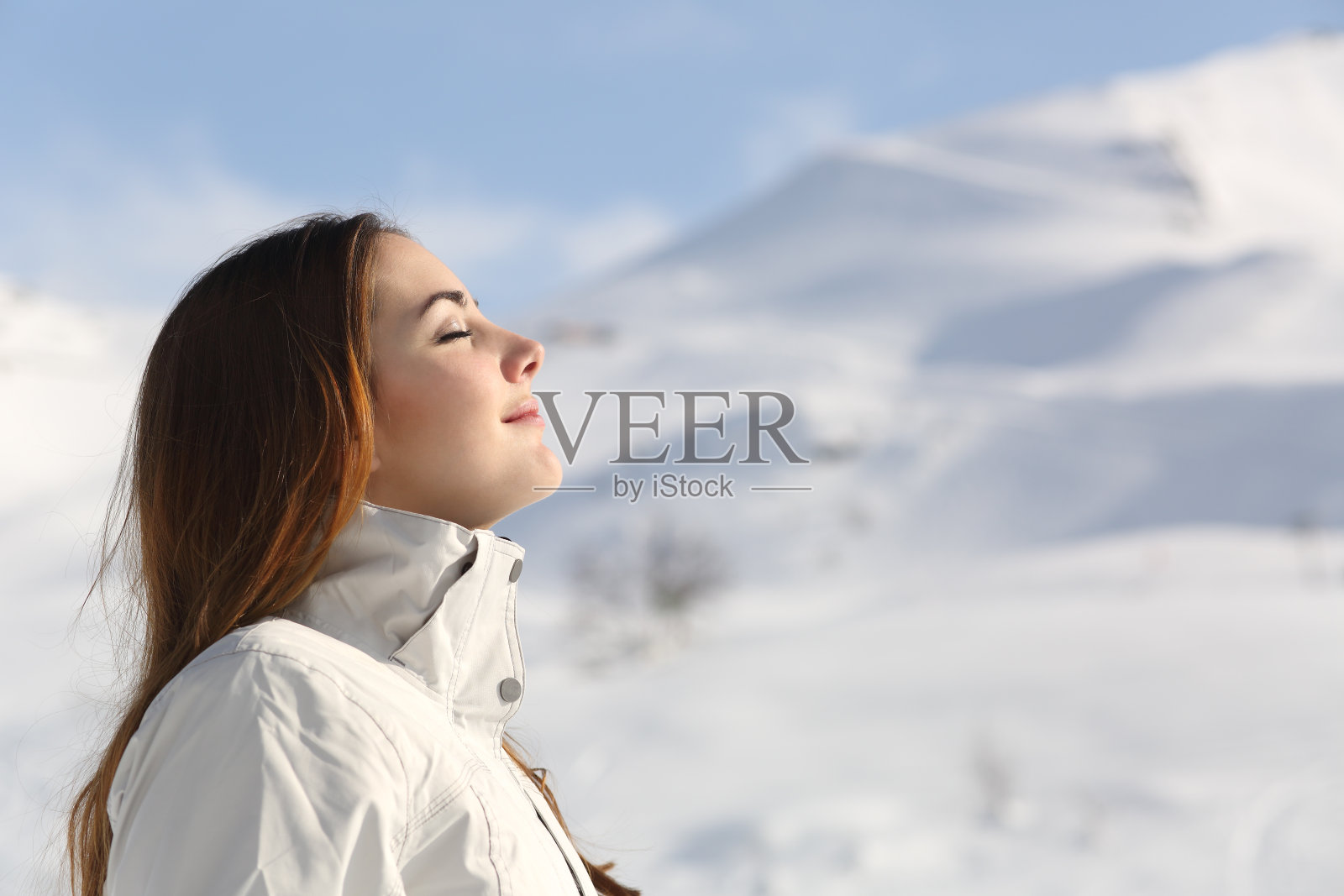 冬天在雪山里呼吸新鲜空气的女人照片摄影图片