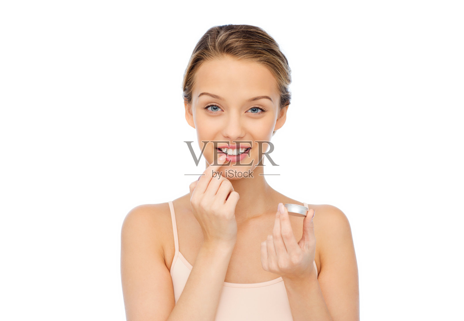 微笑的年轻女子在嘴唇上涂润唇膏照片摄影图片