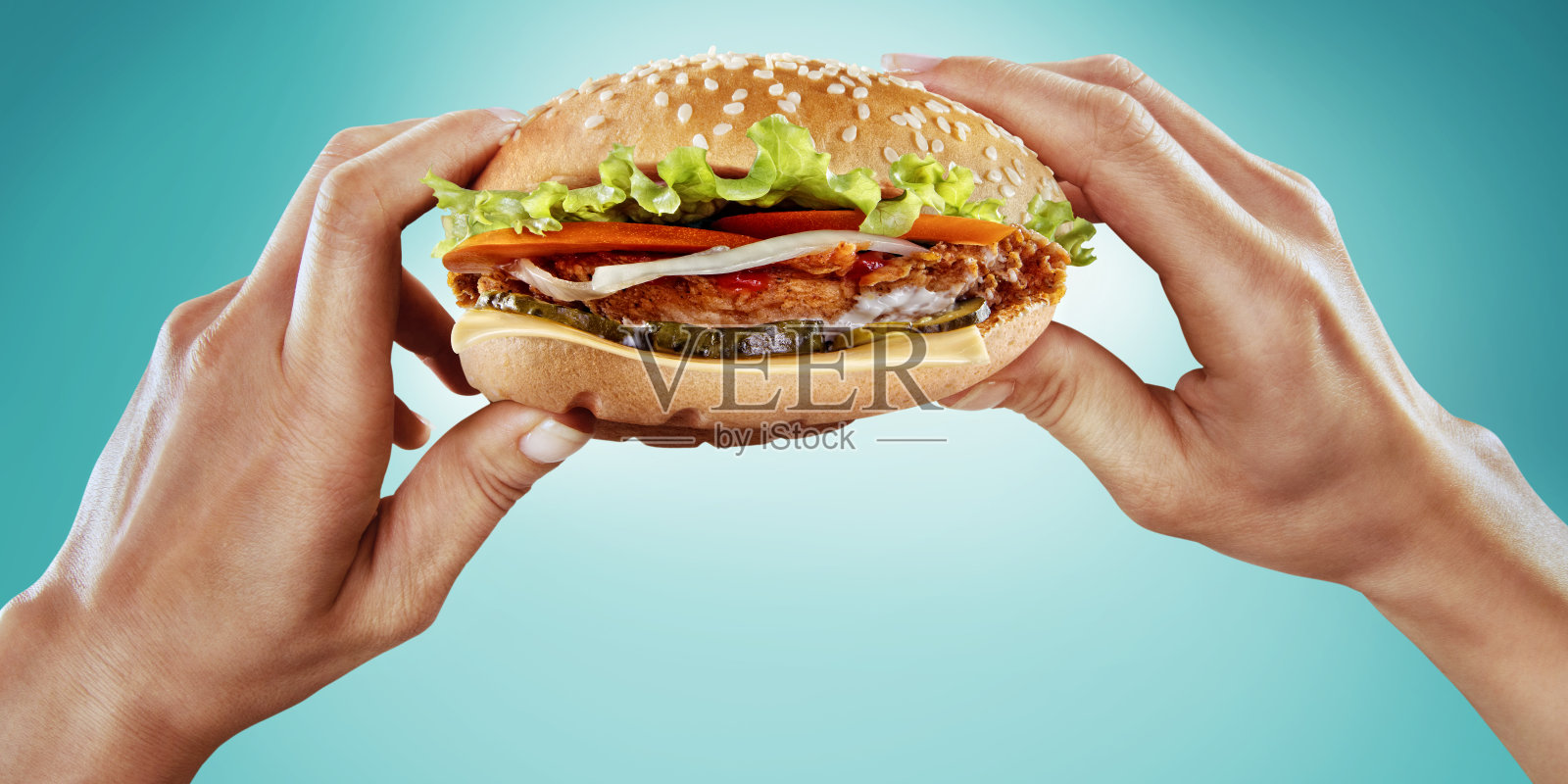 手里拿着美味的汉堡。饮食和快餐。照片摄影图片
