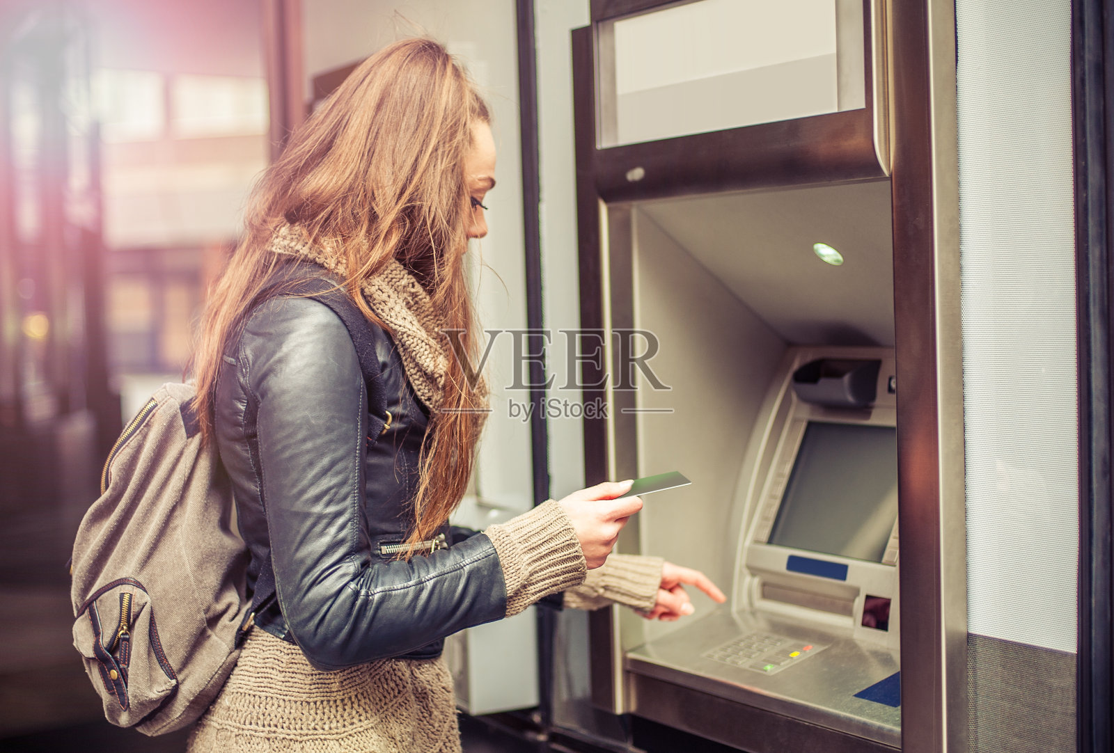 年轻女子从自动取款机取钱照片摄影图片