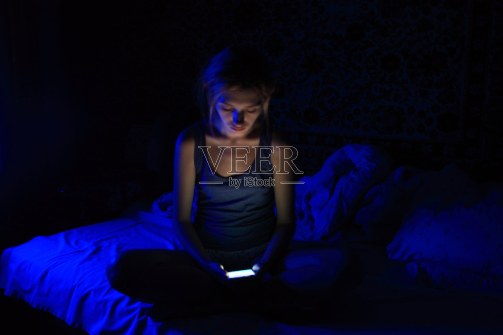 年轻女性在睡前使用智能手机照片摄影图片