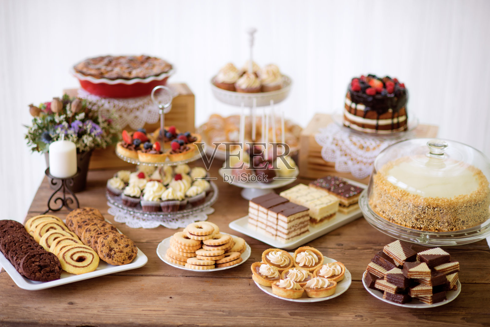 桌子上有各种饼干，馅饼，蛋糕，纸杯蛋糕和蛋糕棒棒糖照片摄影图片