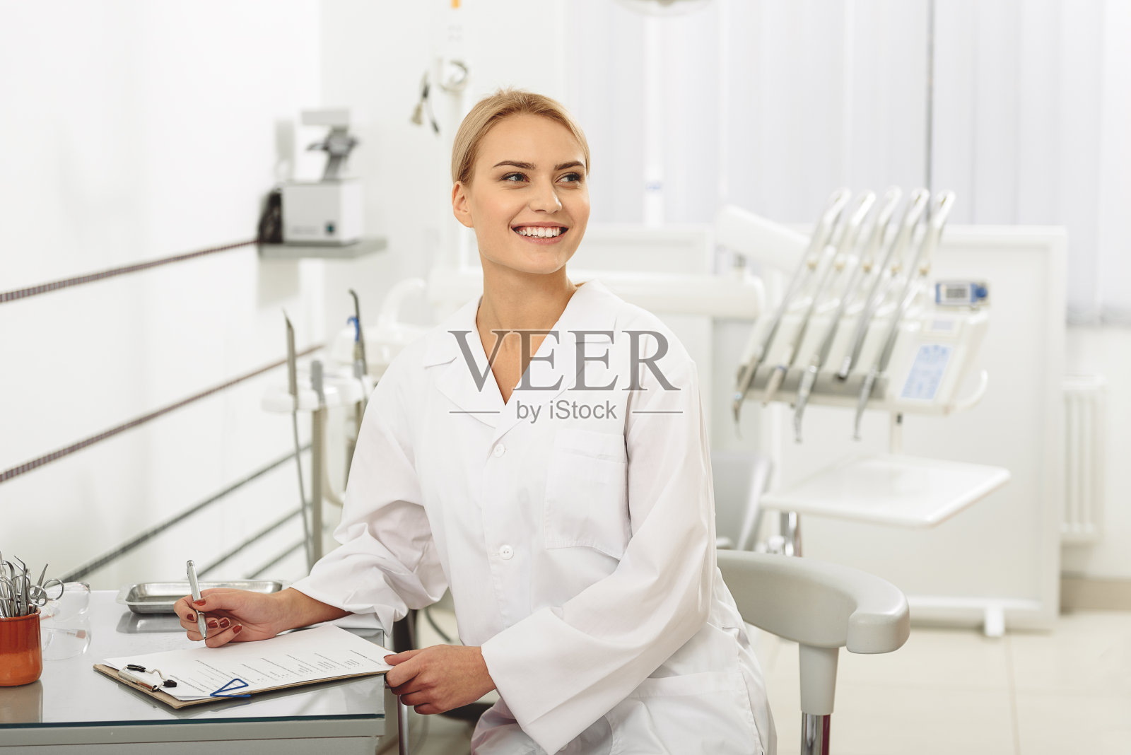 可爱的快乐口腔医生坐在牙科诊所照片摄影图片