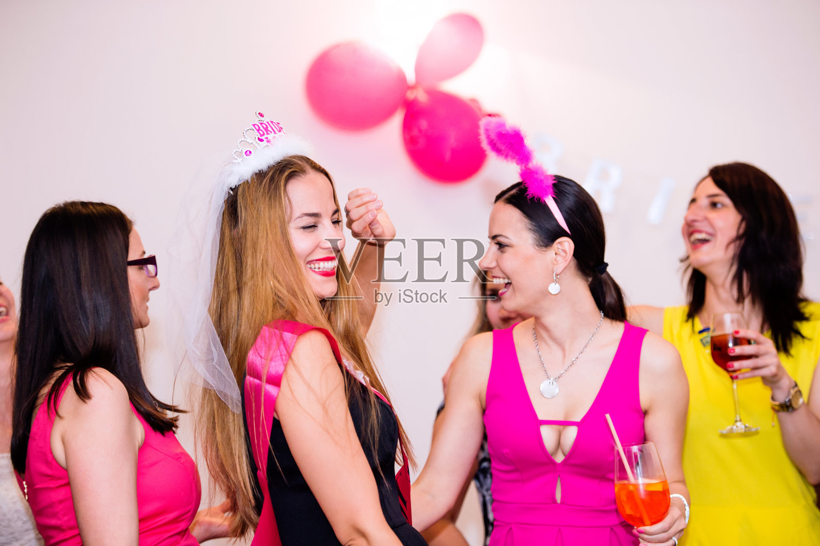 快乐的新娘和伴娘用饮料庆祝女性聚会照片摄影图片