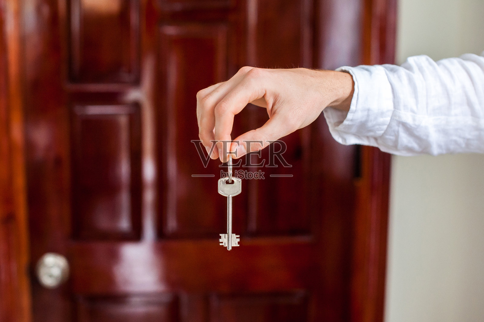 男人的手握家钥匙上的背景照片摄影图片