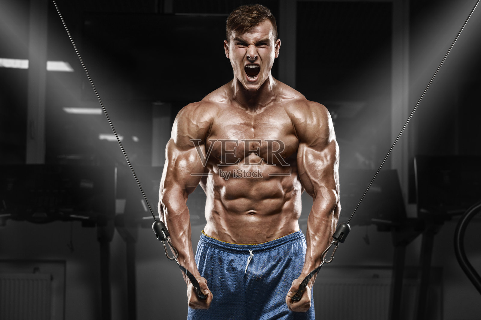 肌肉男在健身房锻炼，强壮的男性躯干腹肌照片摄影图片