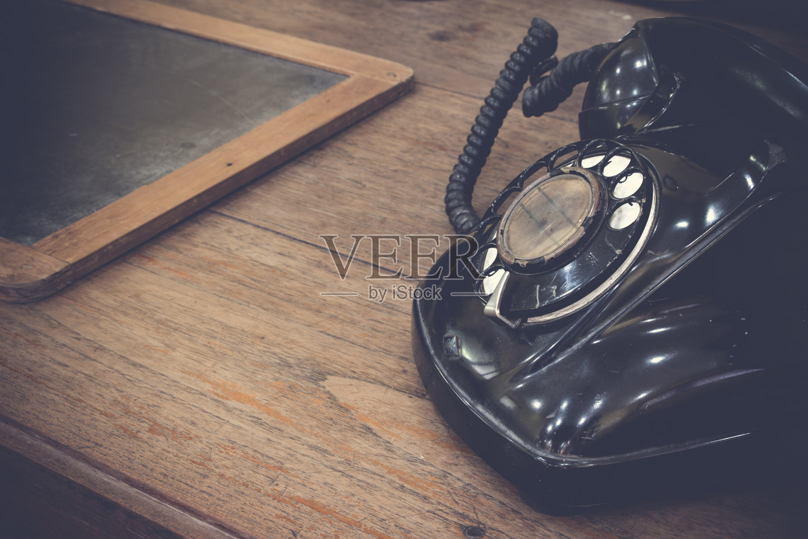 黑色的老式模拟电话拨号与旧石板。照片摄影图片