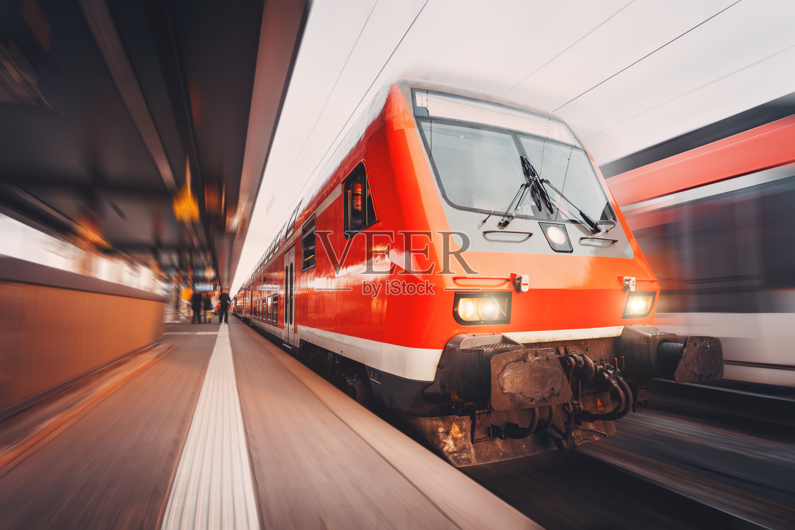 日落时分的现代高速红色客运列车。火车站照片摄影图片