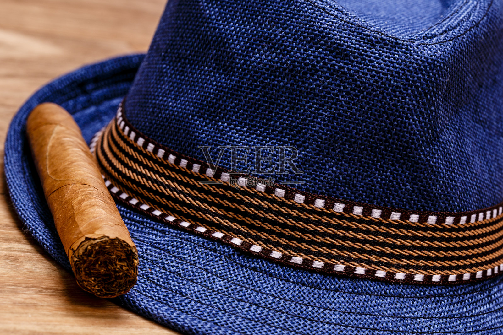 蓝帽子和雪茄在木地板上，烟的概念照片摄影图片