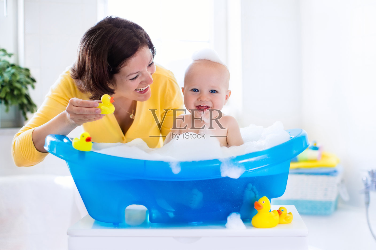 年轻的母亲正在给男婴洗澡照片摄影图片