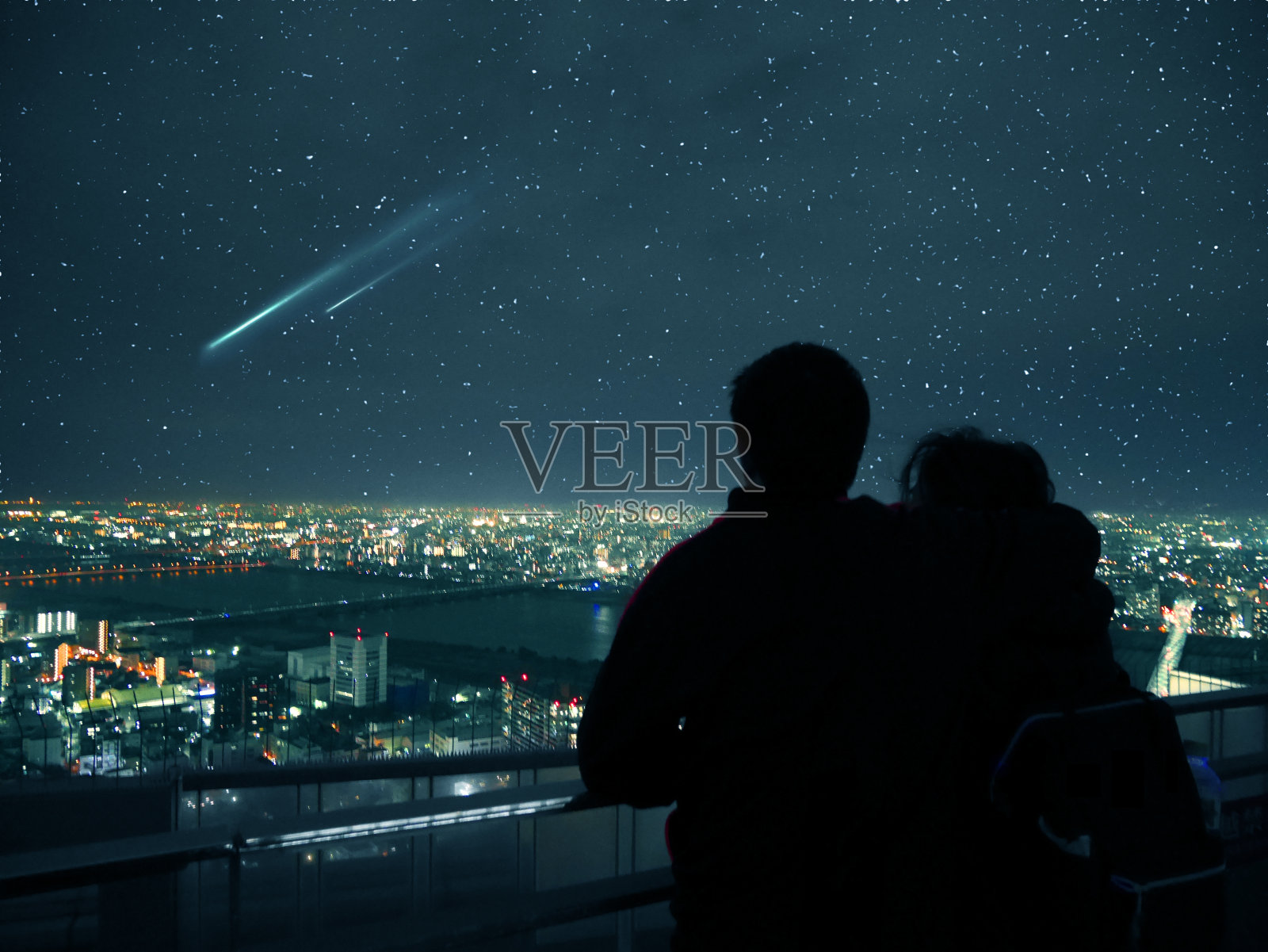 一对夫妇俯瞰大阪的夜空和流星照片摄影图片