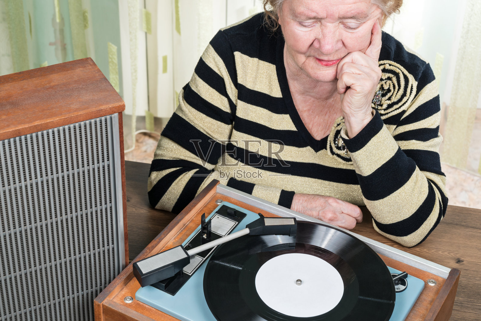老妇人在听转盘上的音乐照片摄影图片
