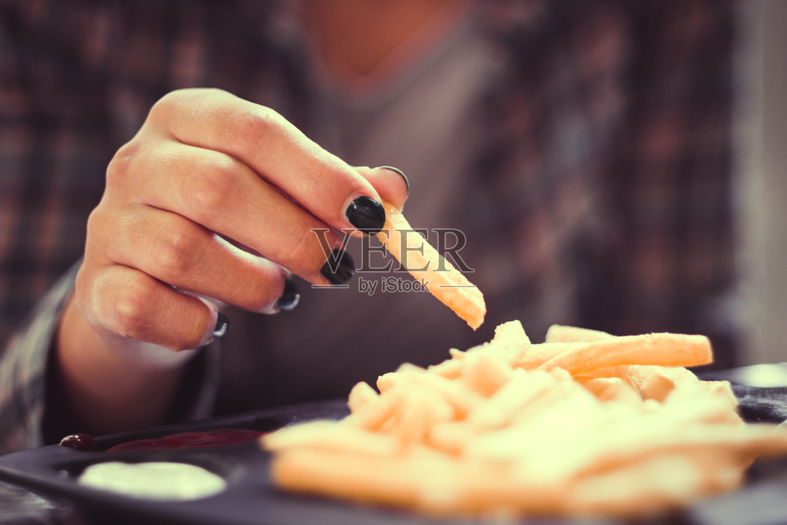 有绿色指甲的女人在餐馆里烤薯条照片摄影图片