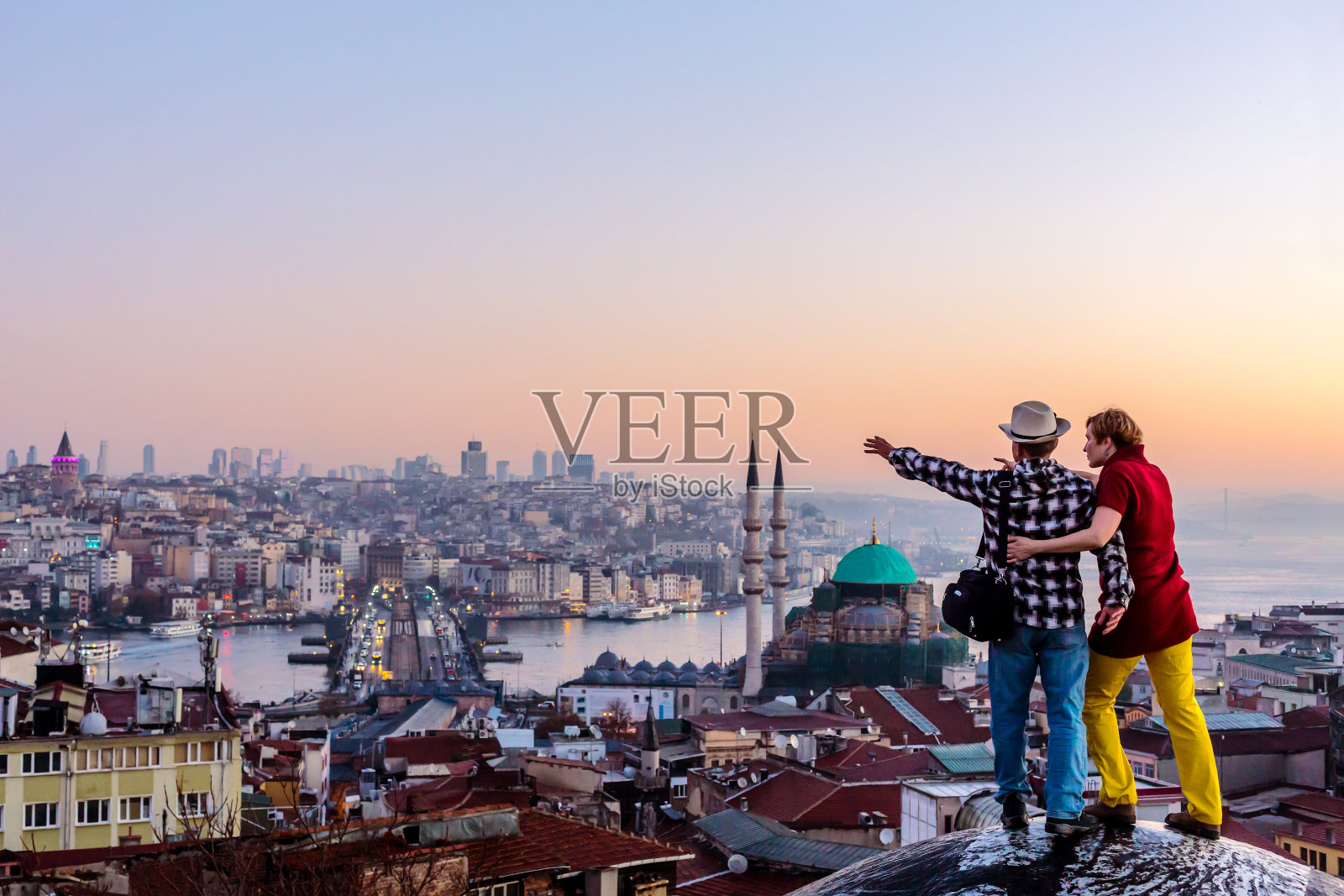 一起旅行的夫妇住在屋顶上，俯瞰城市景观照片摄影图片