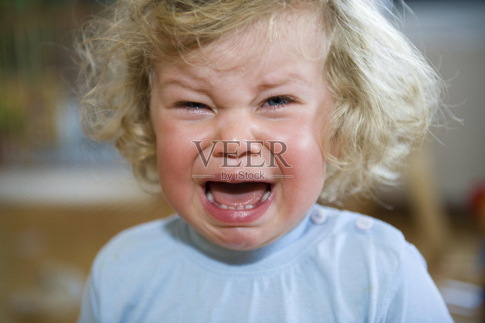 一个穿着蓝色衬衫的孩子在哭照片摄影图片