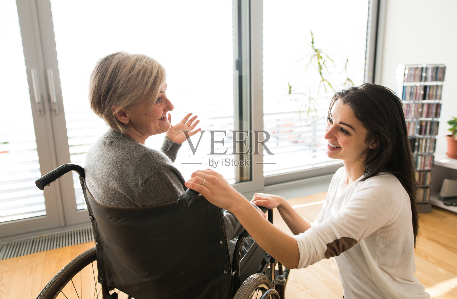 坐在轮椅上的残疾老年妇女和她年幼的女儿。照片摄影图片