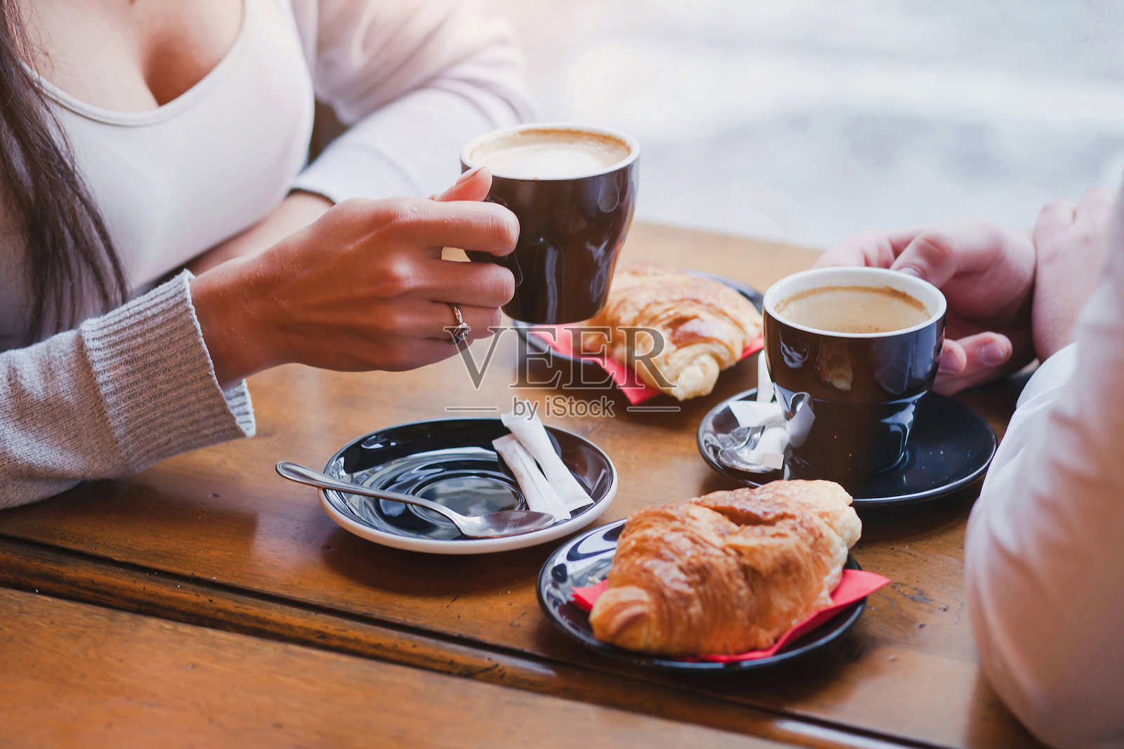 咖啡和羊角面包在咖啡馆，夫妇正在吃早餐照片摄影图片