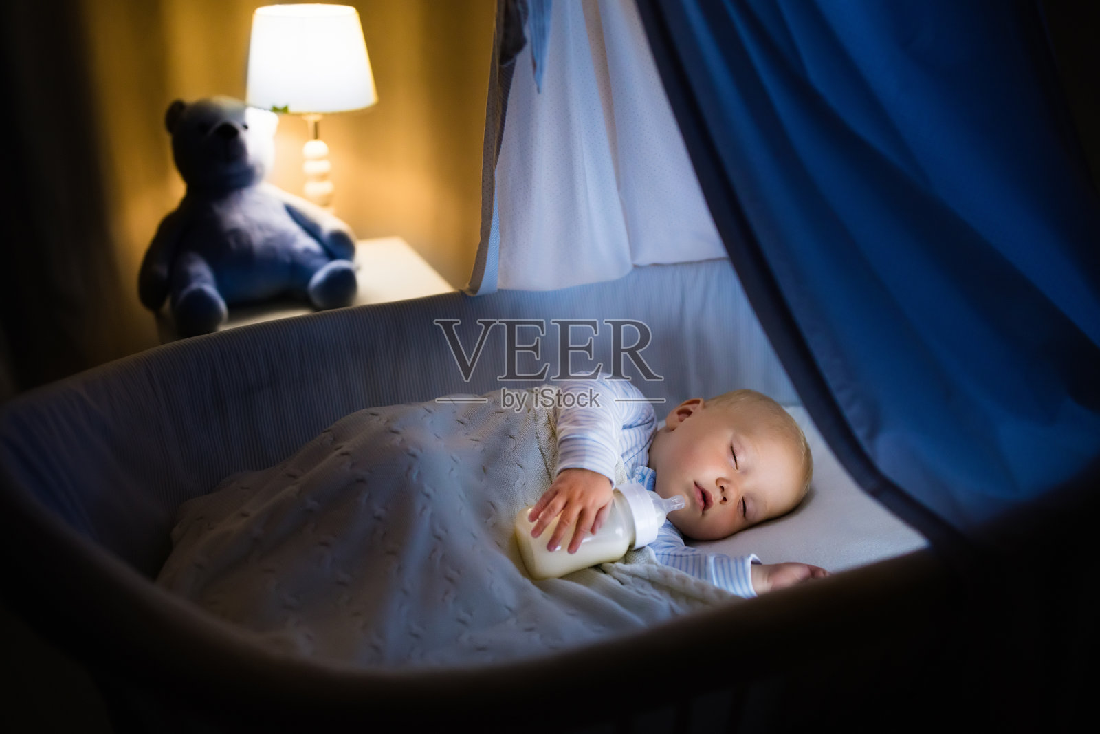 小男孩在婴儿床里喝牛奶照片摄影图片