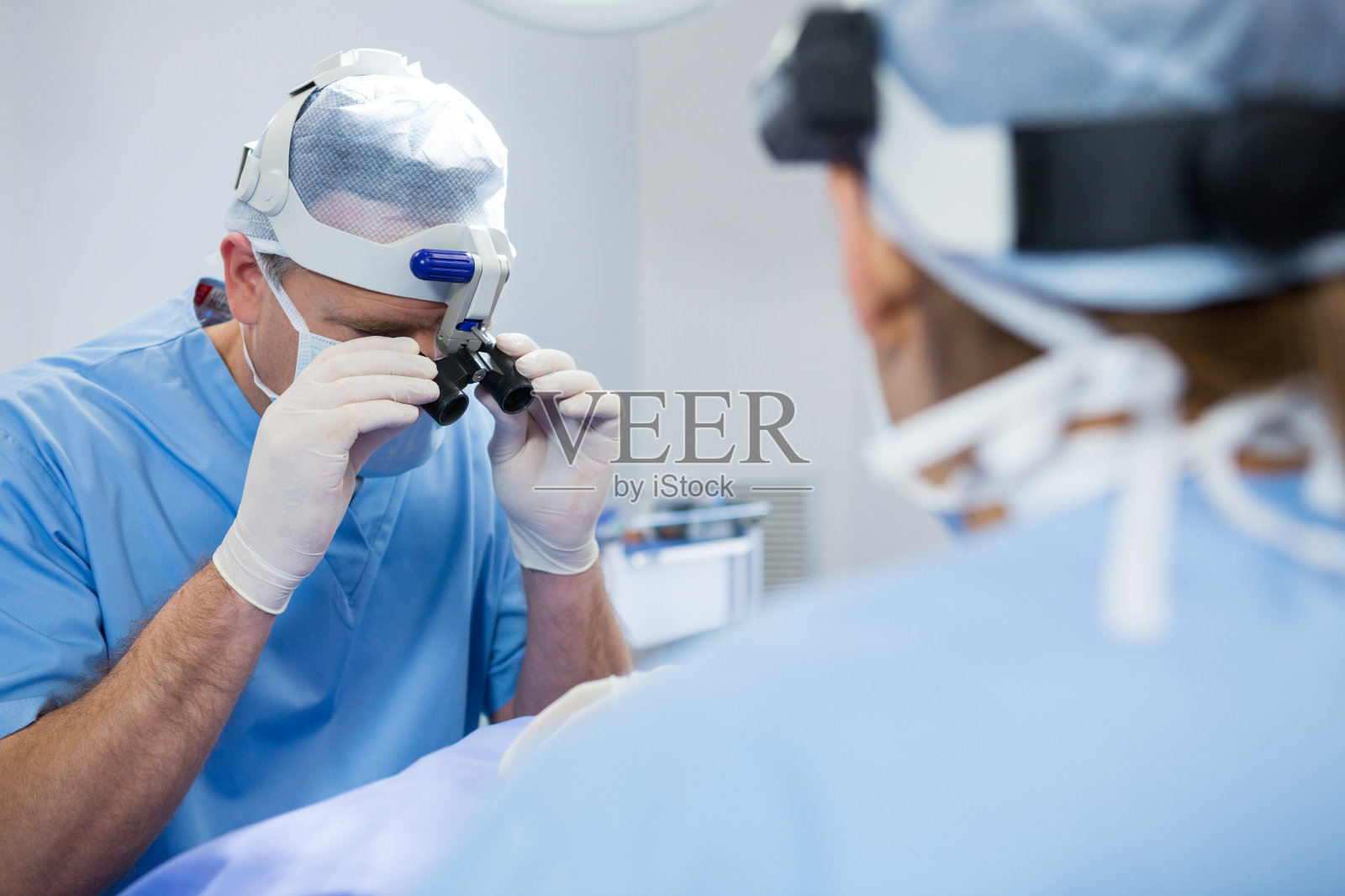 外科医生在给病人做手术时戴手术镜照片摄影图片