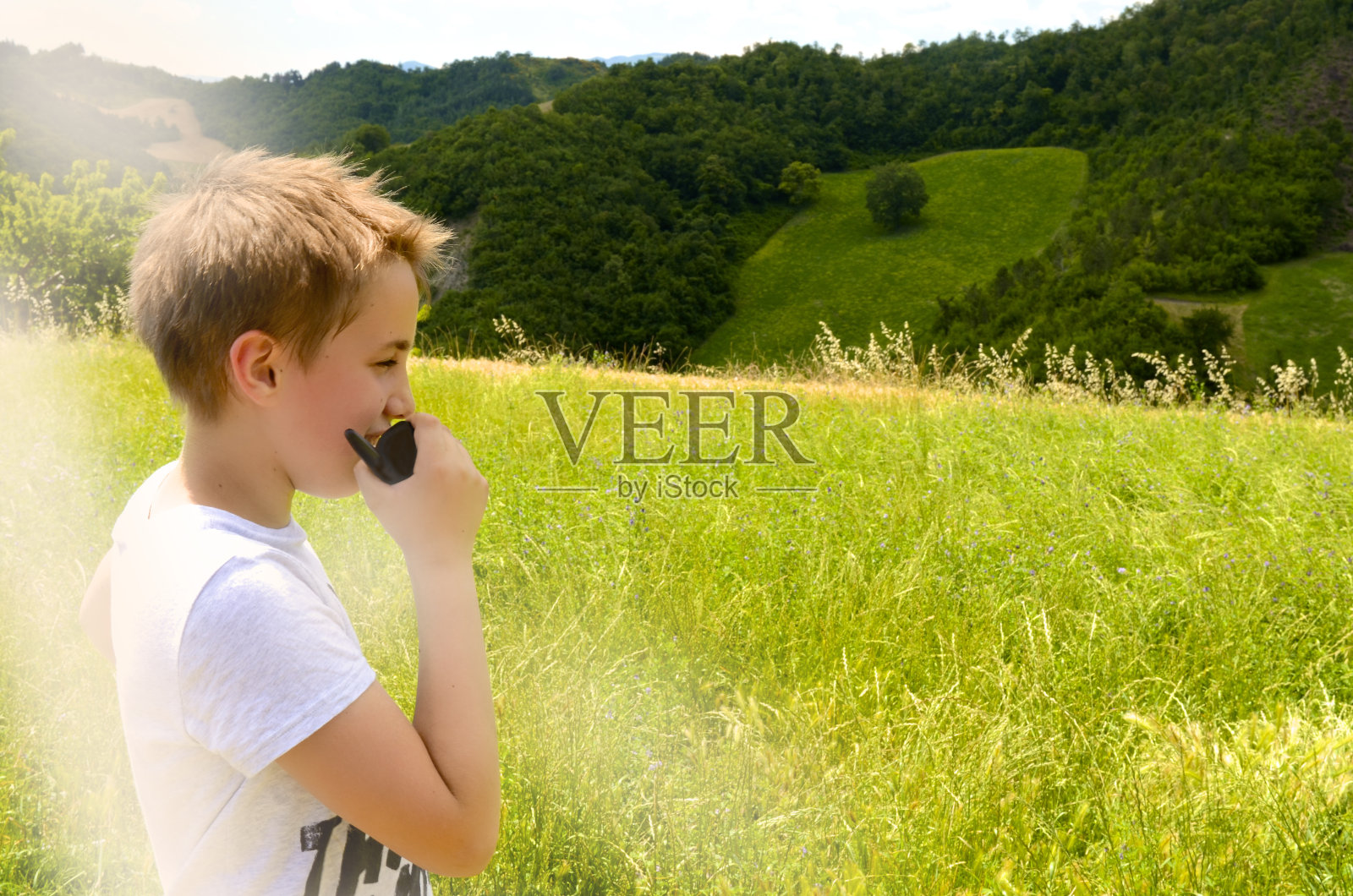 男孩在绿色山谷用对讲机聊天照片摄影图片