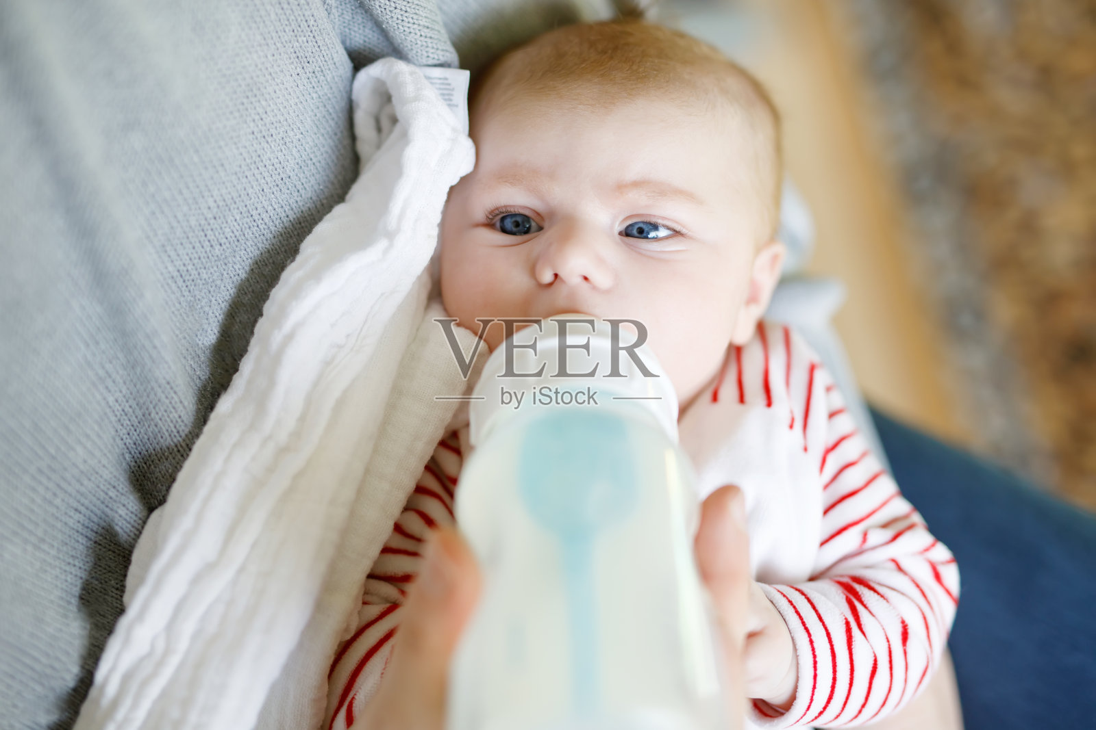 父亲用奶瓶喂刚出生的女儿照片摄影图片