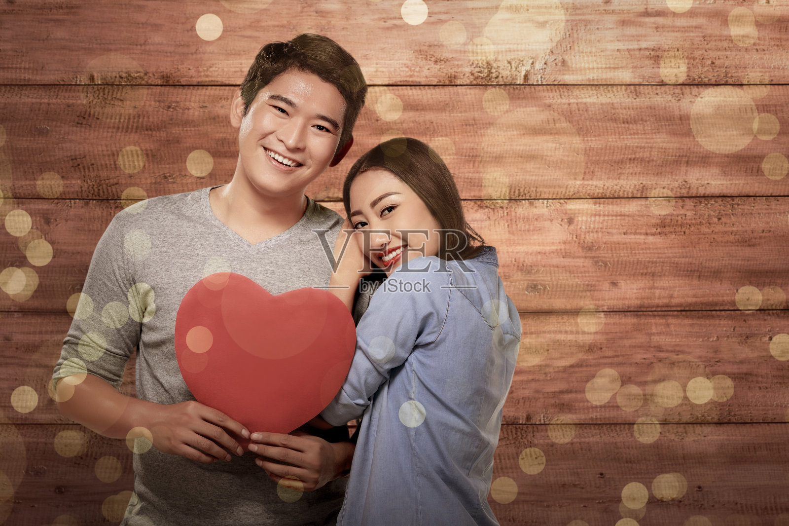 微笑的亚洲情侣在爱持有红心的象征照片摄影图片