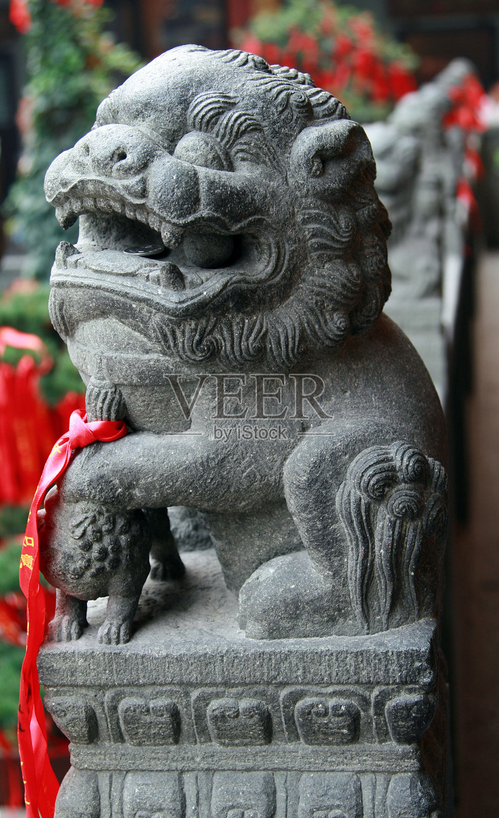 中国传统的守护狮——雄狮将爪子放在绣球上(代表着至高无上的地位)照片摄影图片