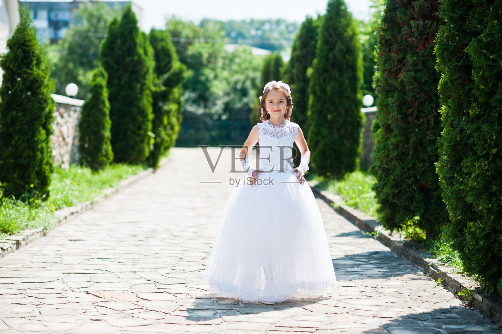 可爱的小女孩的肖像在白色的连衣裙和花环的第一圣餐的背景杜嘉巷照片摄影图片