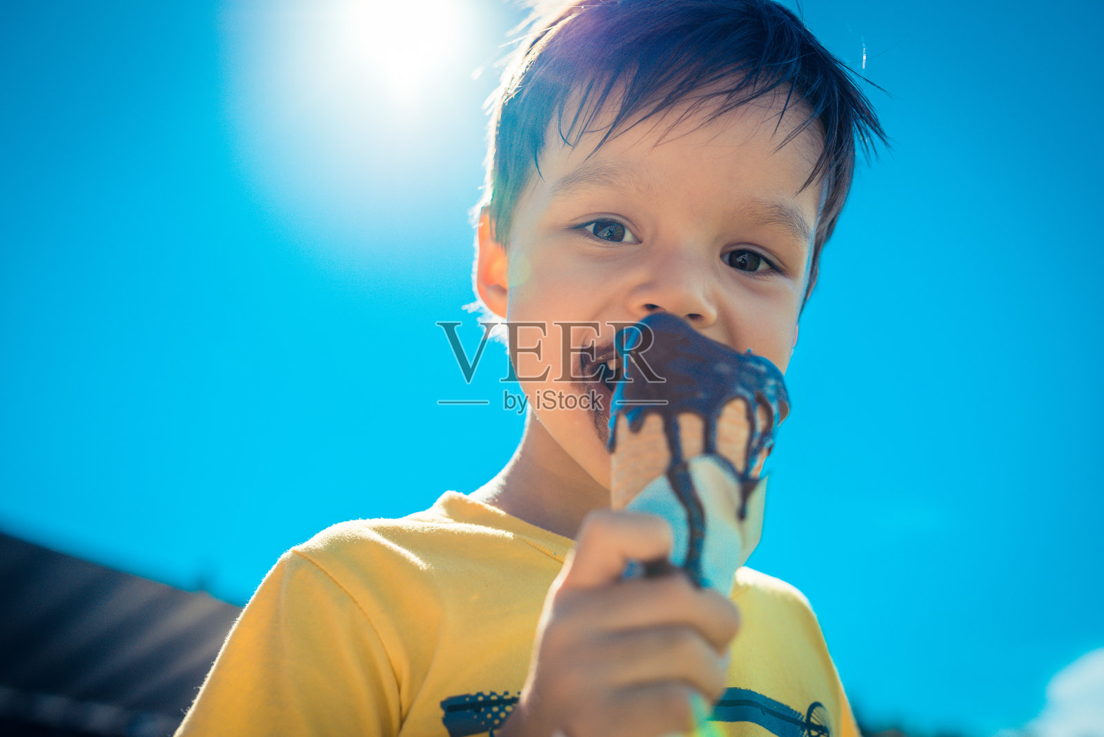 三岁的男孩吃巧克力冰淇淋照片摄影图片