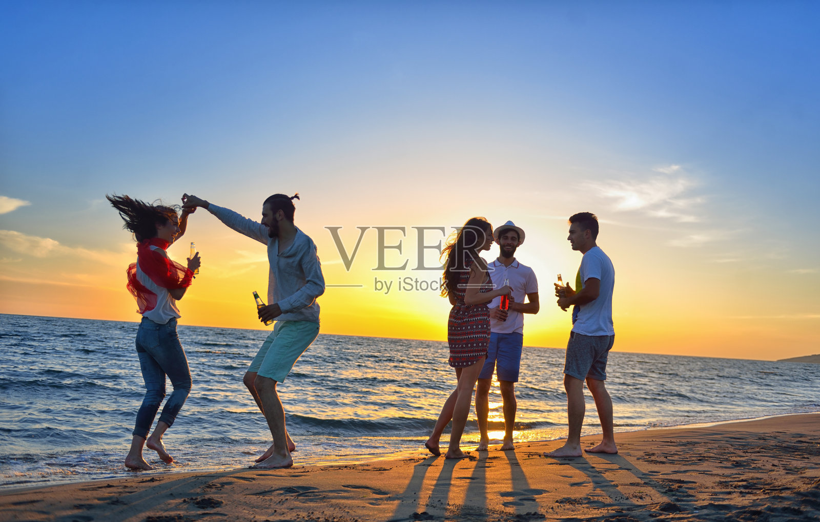 一群年轻人在海滩上跳舞照片摄影图片