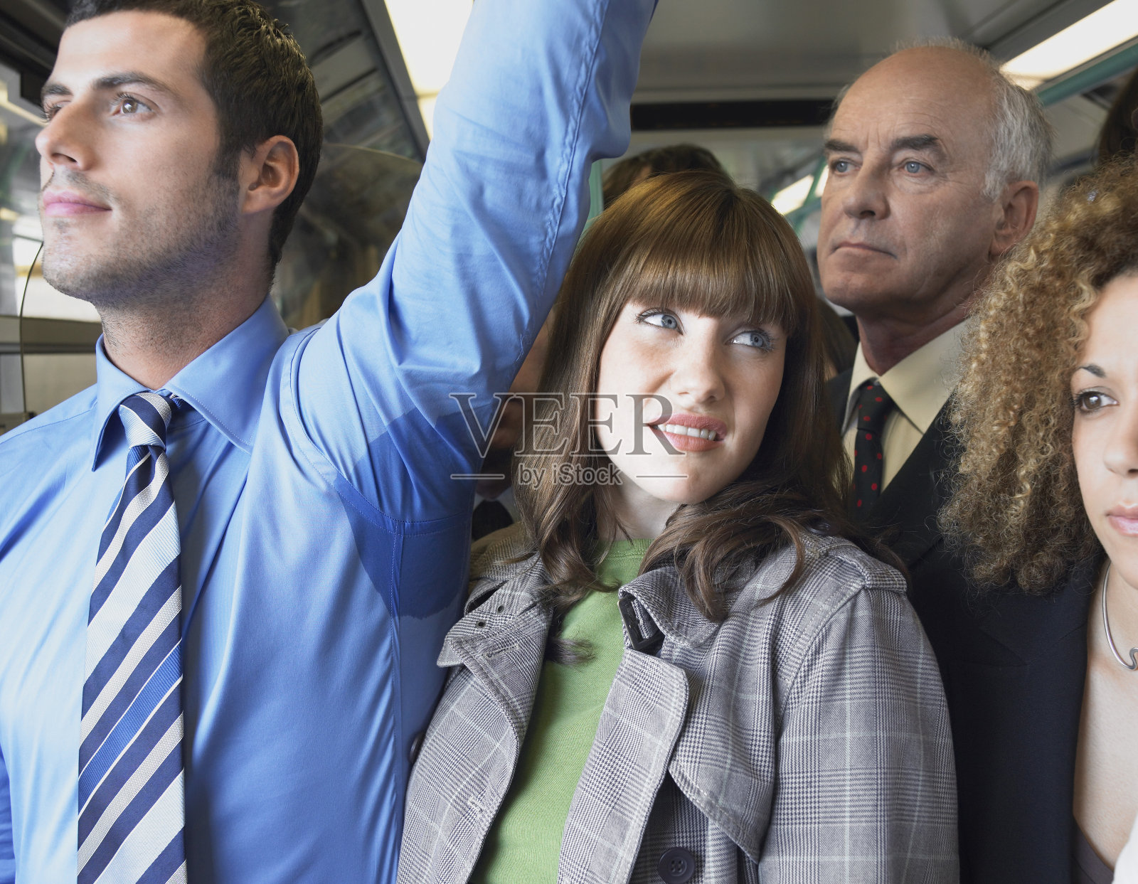 火车上，女性乘客站在男人湿腋下照片摄影图片