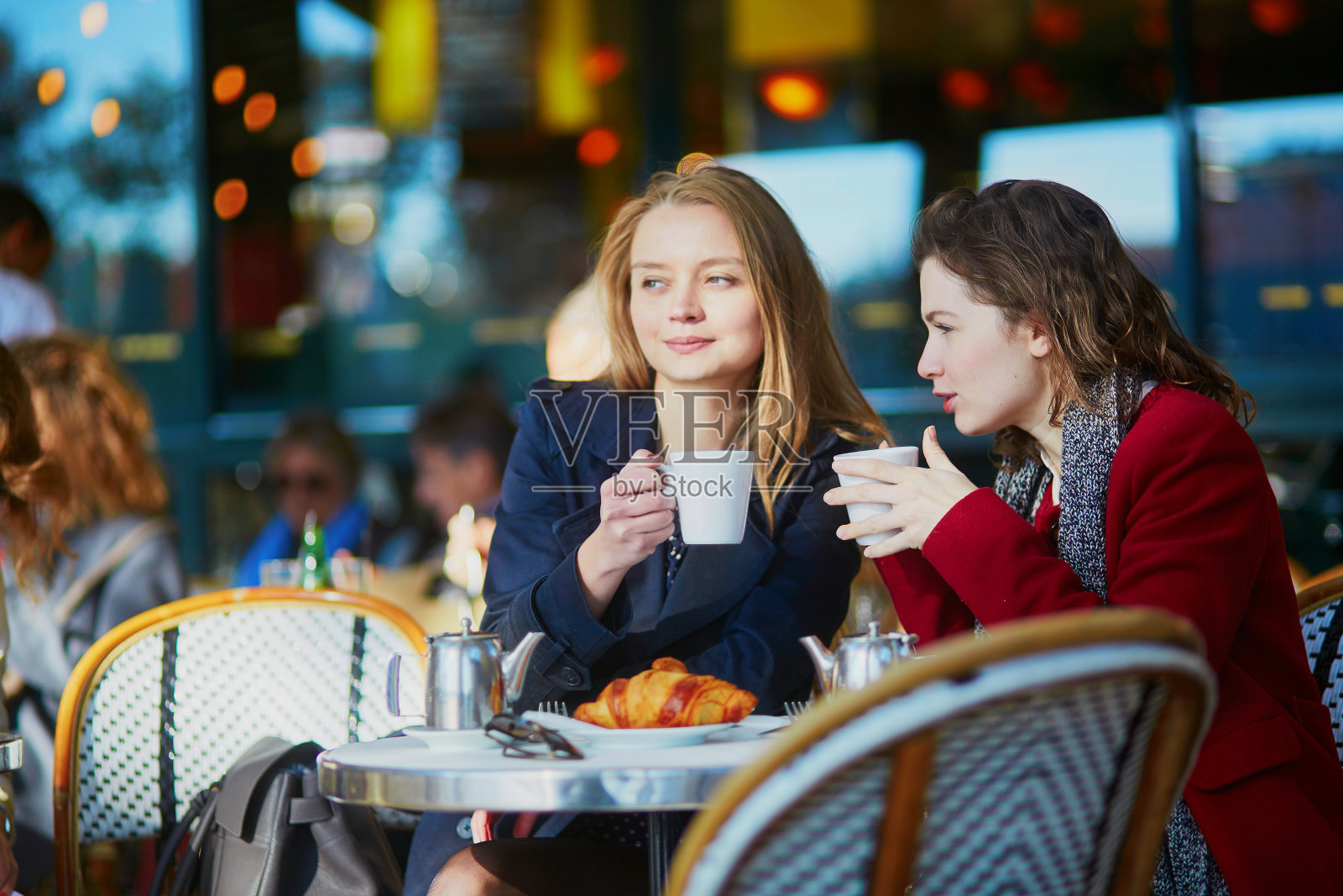 两个年轻女孩在巴黎的露天咖啡馆照片摄影图片