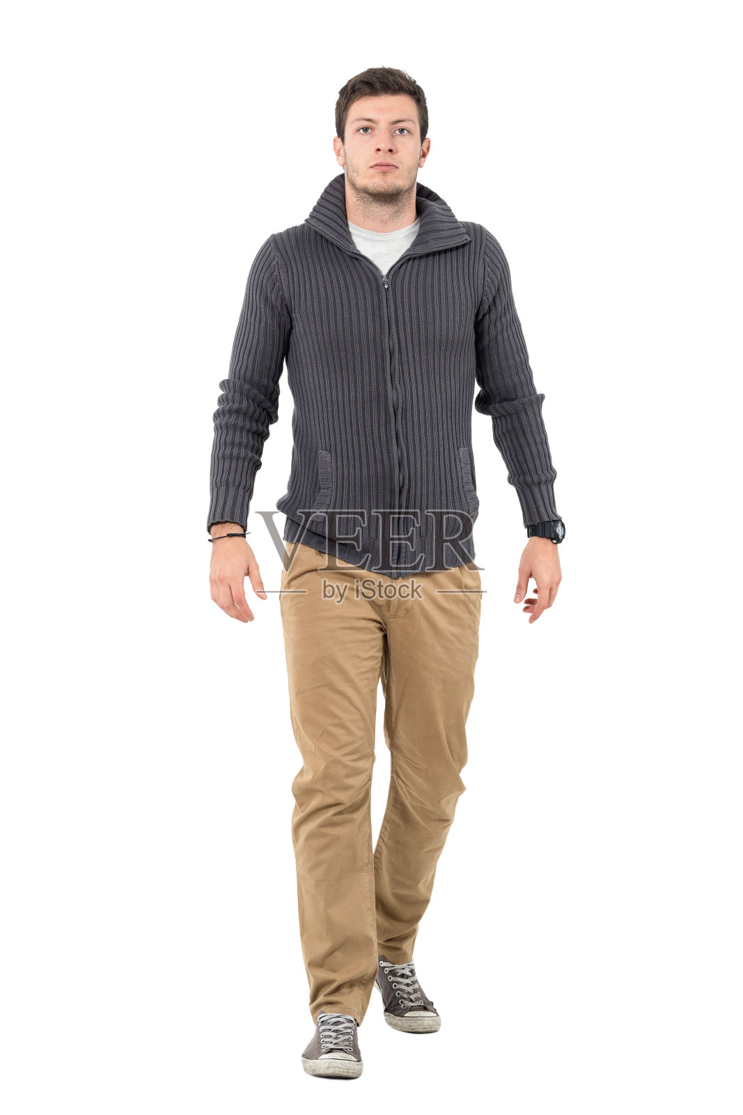 一个穿着套头衫和米色裤子的严肃男人走在镜头前照片摄影图片
