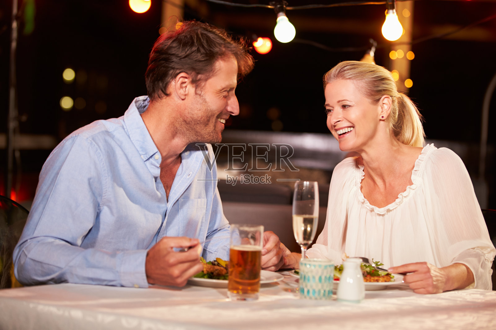 一对夫妇在屋顶餐厅吃晚餐照片摄影图片