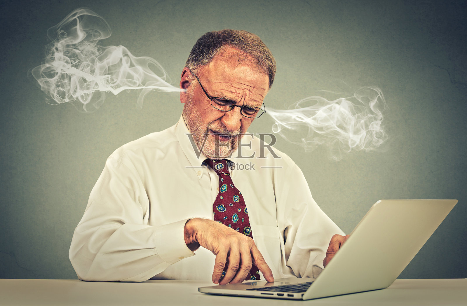 紧张的老人用电脑从耳朵吹蒸汽照片摄影图片
