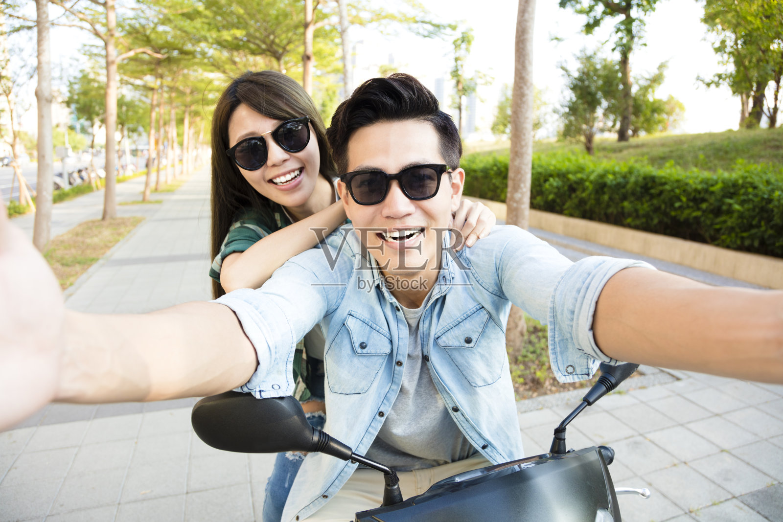 快乐的年轻夫妇骑着滑板车自拍照片摄影图片