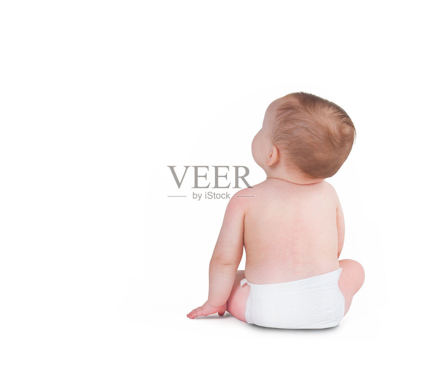 蹒跚学步的婴儿背对着独自坐在白色背景上照片摄影图片