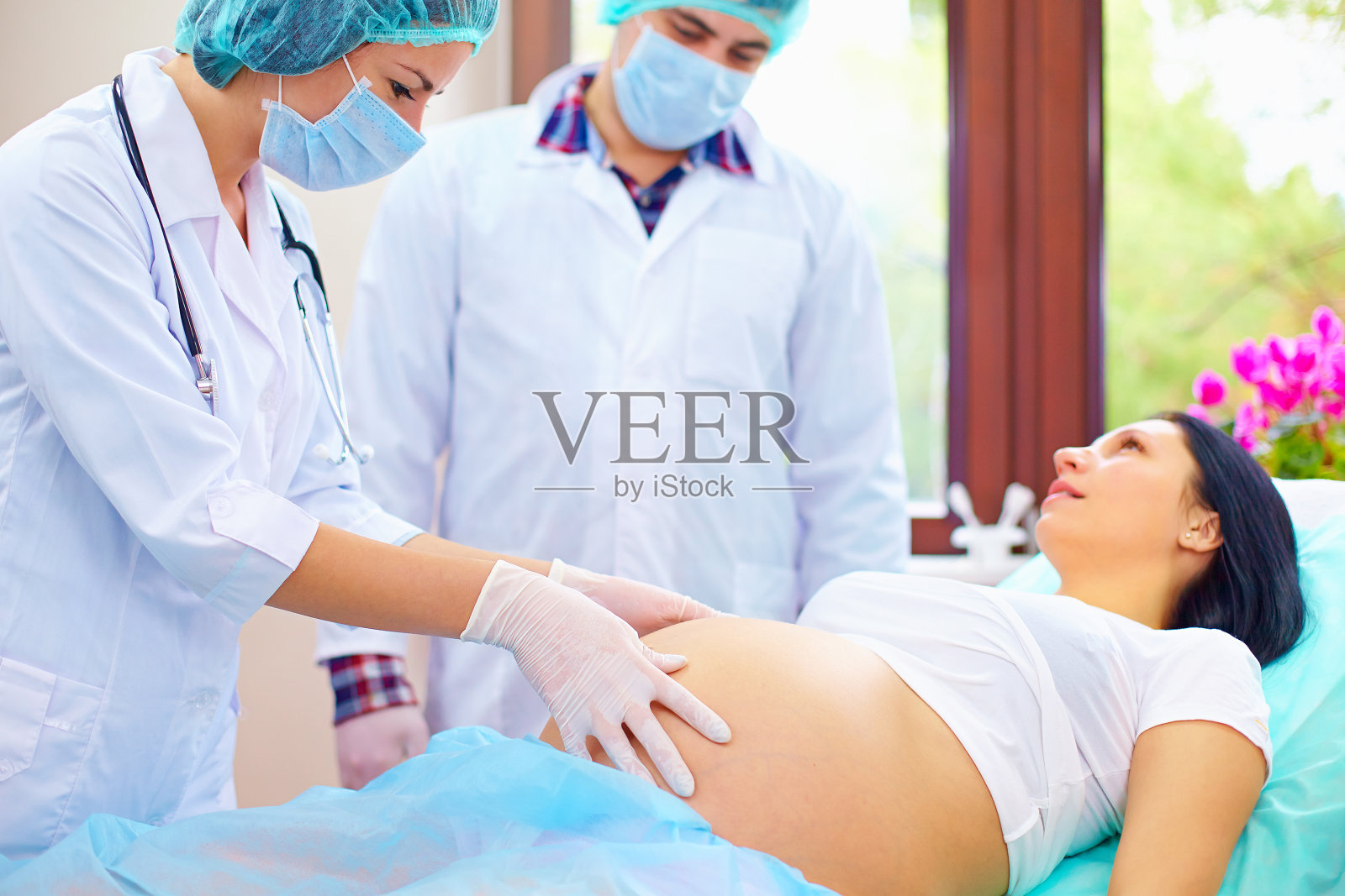 医生在孕妇分娩时触诊腹部照片摄影图片