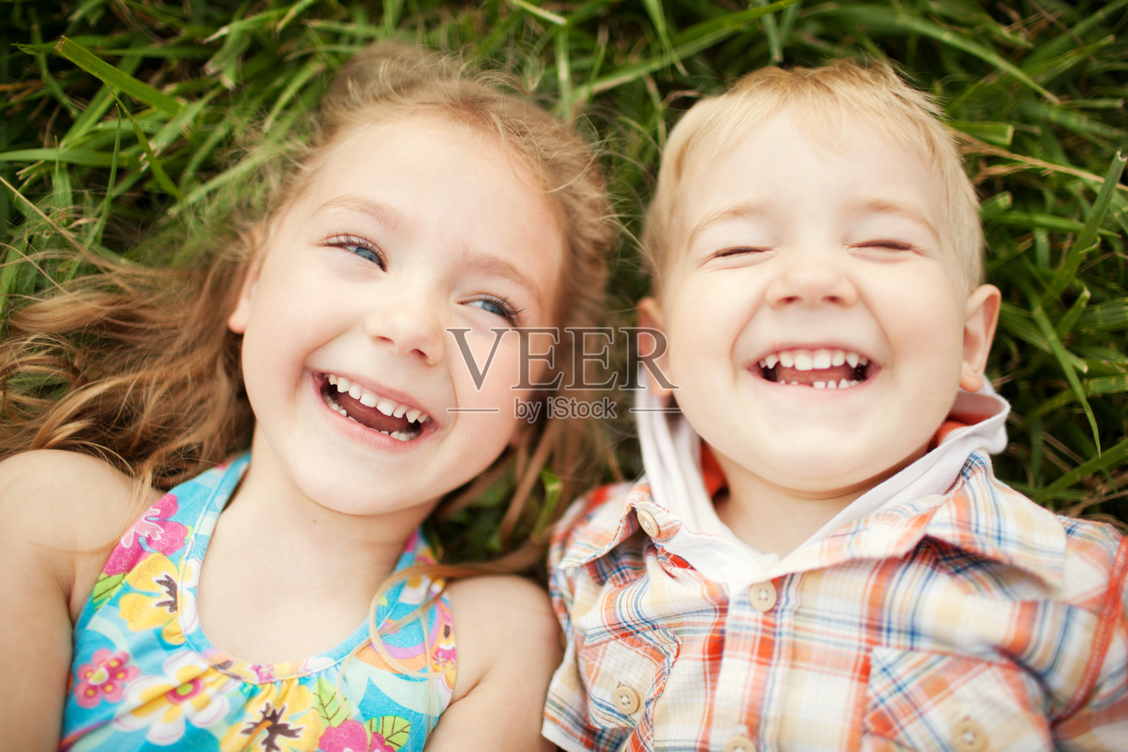 妹妹和弟弟的孩子们在笑。前视图。照片摄影图片