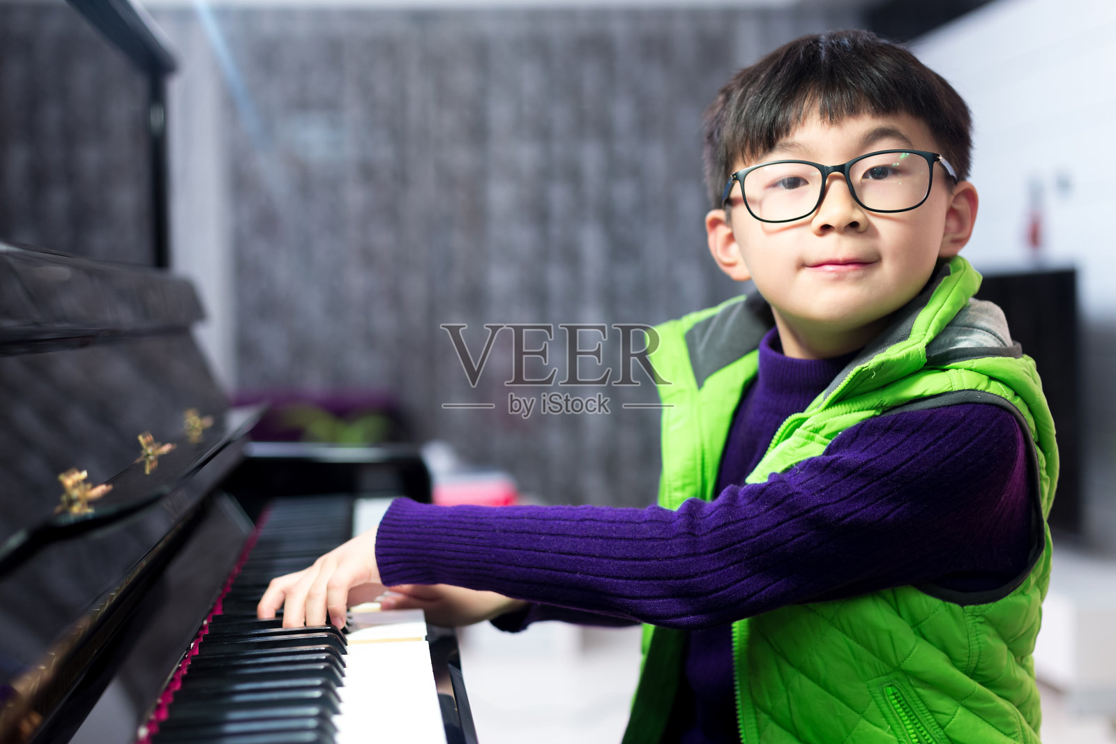 亚洲可爱的男孩在家里弹钢琴照片摄影图片